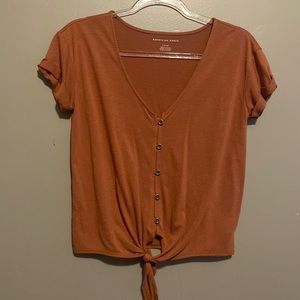 American Eagle burnt orange size small shirt. With buttons and a tie bottom.